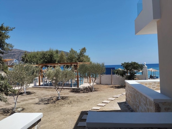 A terrace with outdoor seating, a pergola, and a view of the sea.