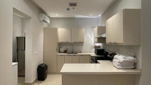 A modern kitchen with a central island, built-in cabinets, and recessed lighting. - FLOWER1 ALMUGHRIZAT (Riyadh)