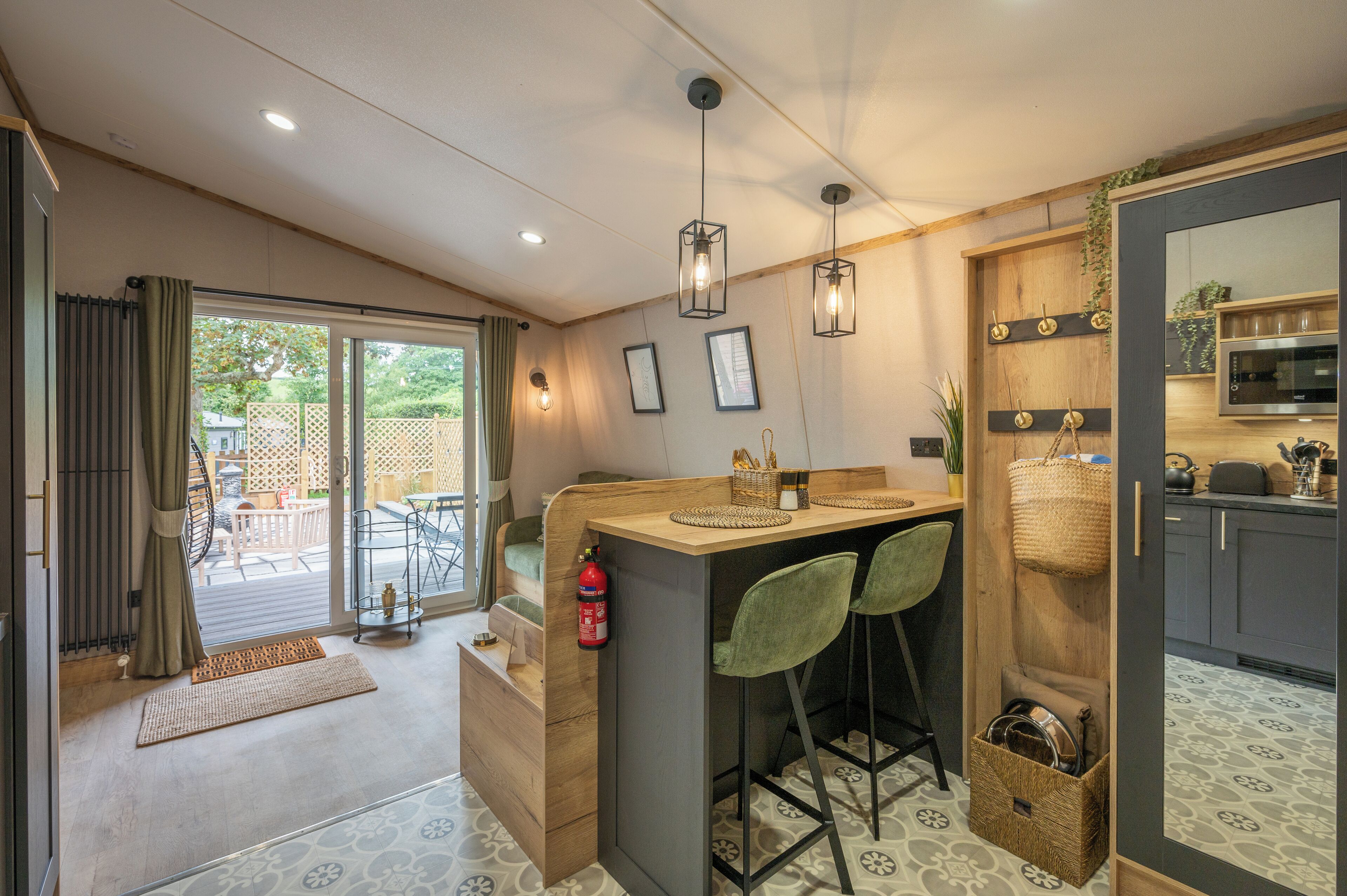 Una cocina compacta con barra, armarios de madera y vista al exterior.