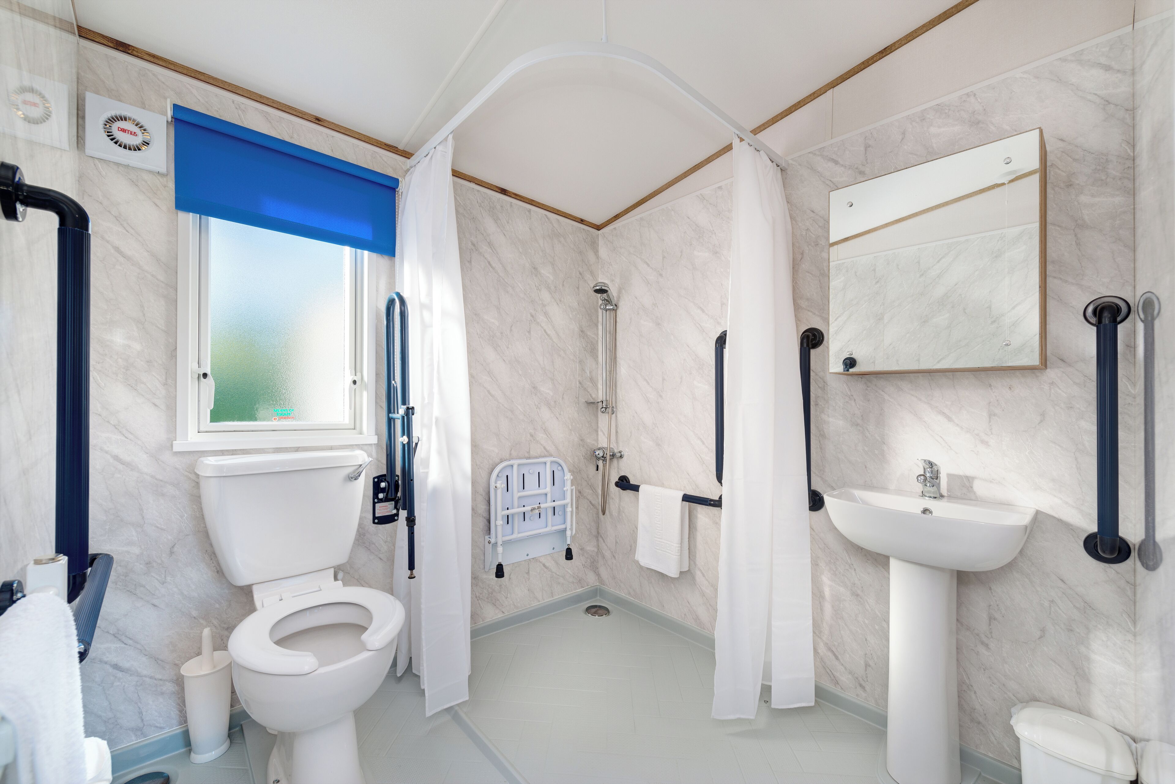 A modern bathroom with a toilet, bidet, sink, and shower.