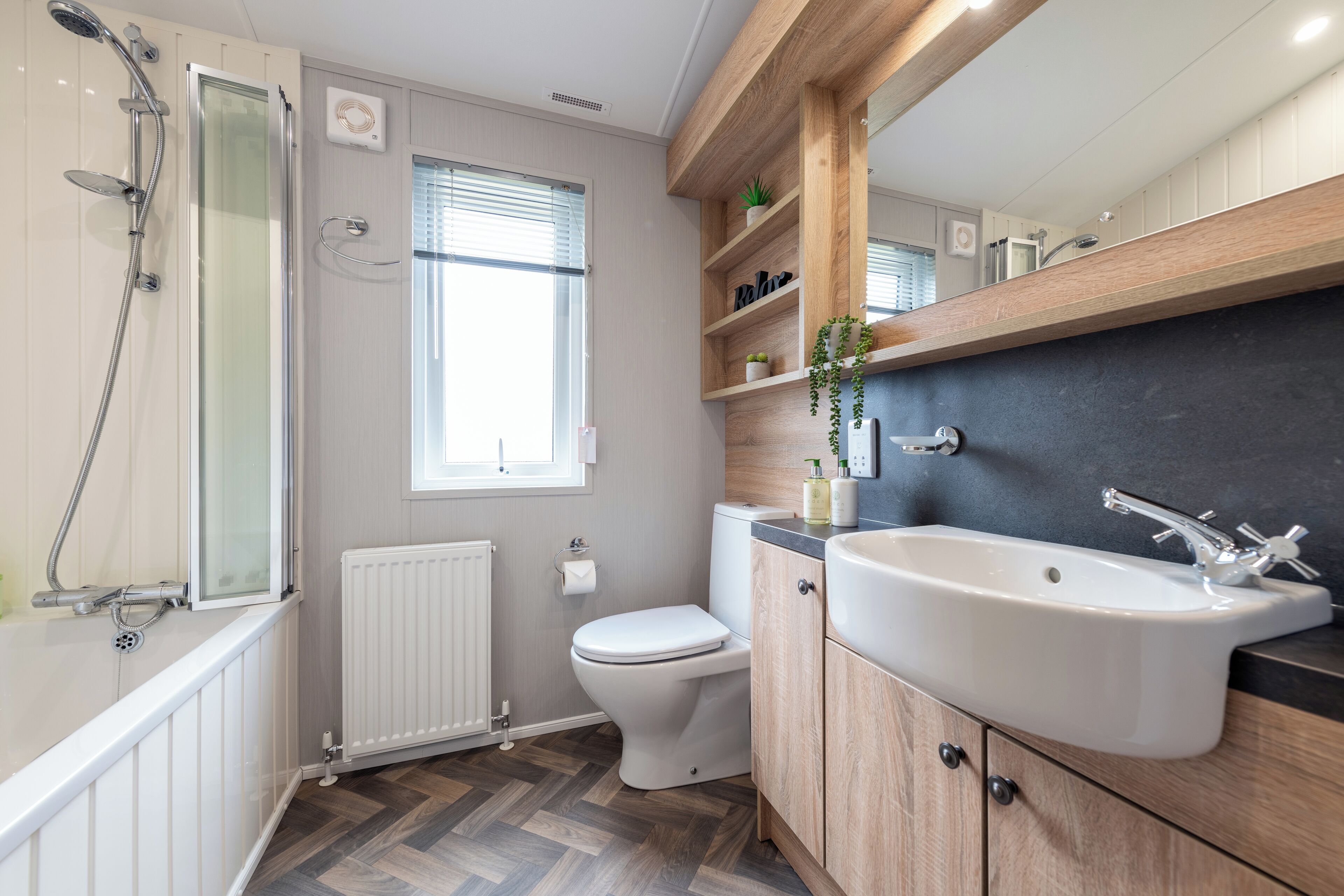 Un baño moderno con ducha, inodoro y lavamanos.