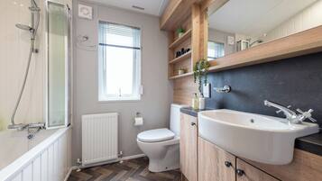 A modern bathroom with a shower, toilet, and sink.