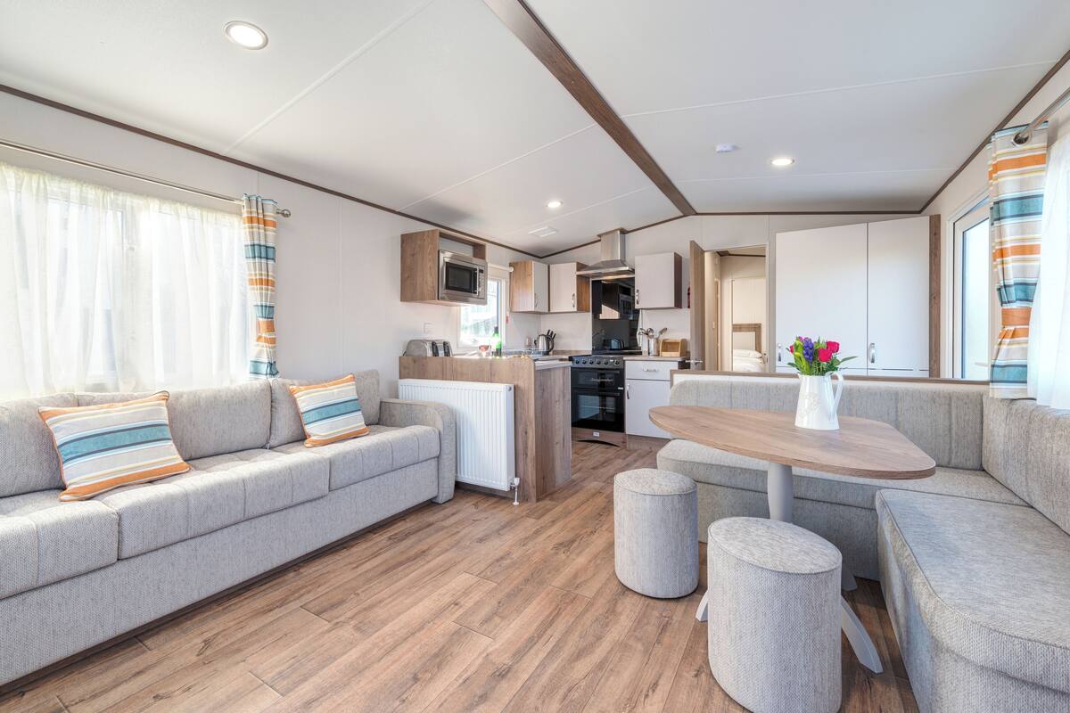 Ein modernes Wohnmobil-Interieur mit Wohnbereich, Küchenzeile und Essplatz.