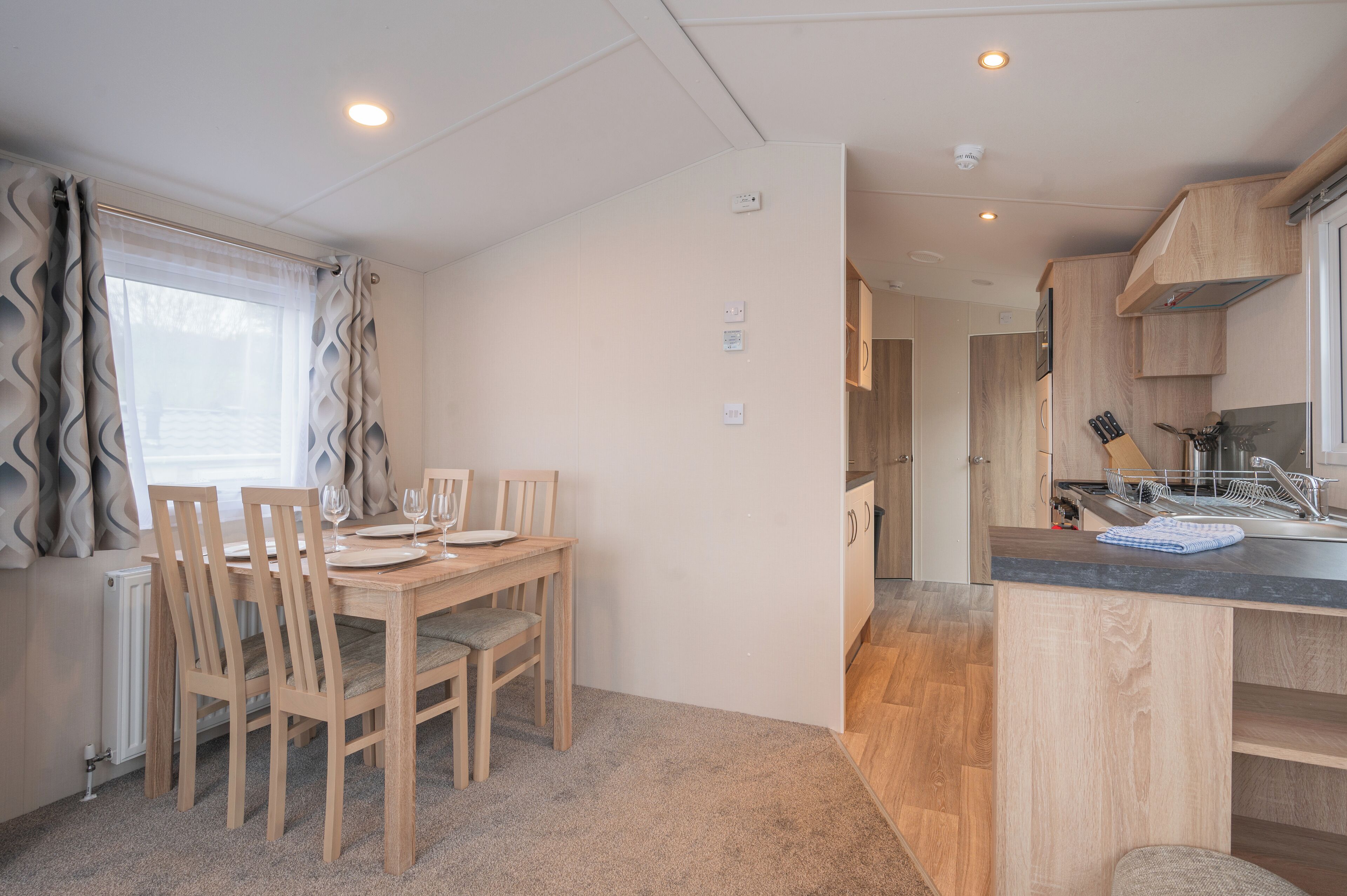 A compact kitchen with wooden cabinets, a built-in dishwasher, and a small countertop.