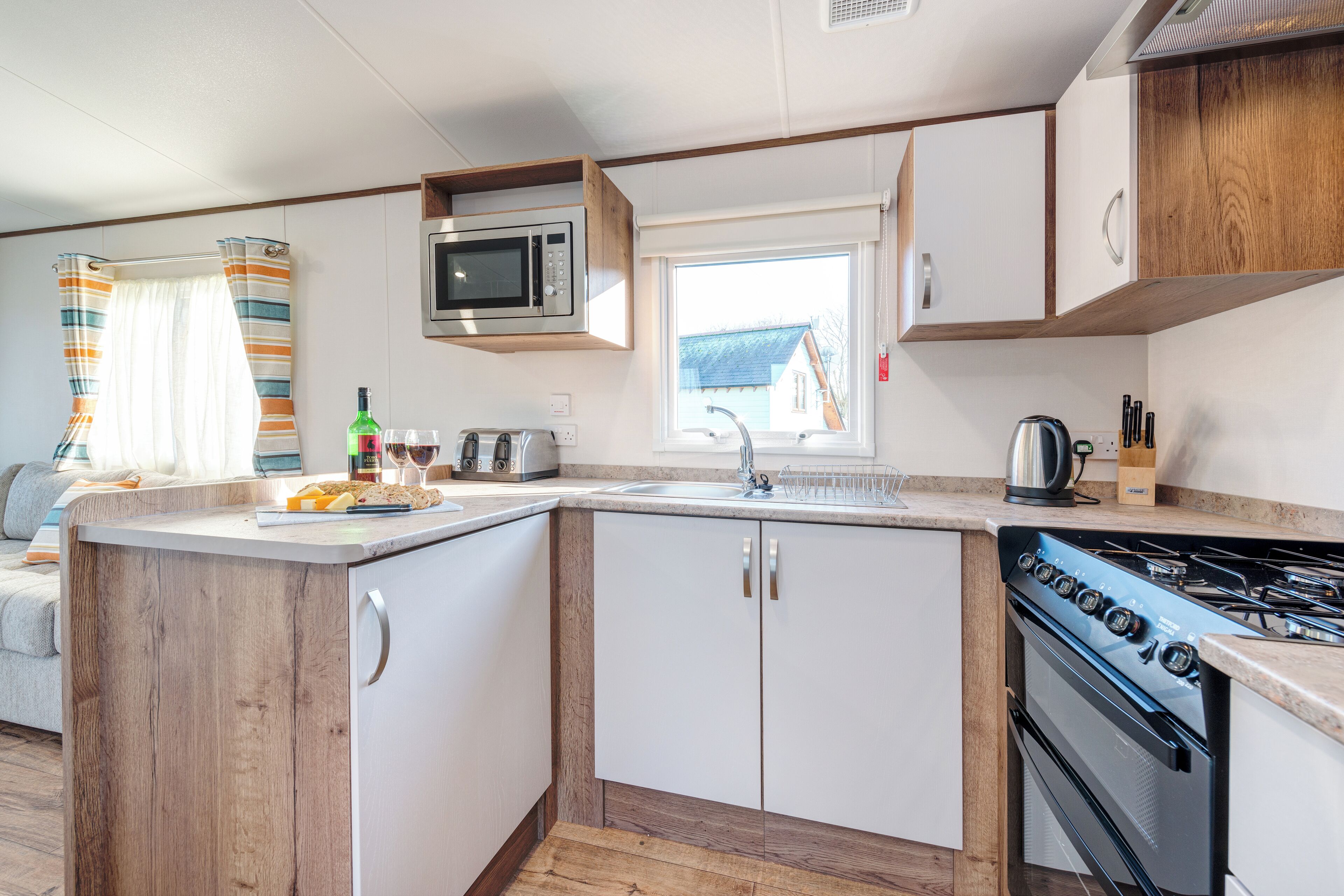 A compact kitchen with a microwave, stove, and sink.