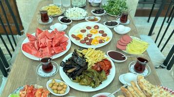 A table set with various dishes, including salads, meats, and bread, with water bottles and condiments.