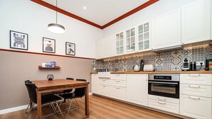 Una cocina moderna con armarios blancos, una mesa de comedor de madera y un salpicadero con estampado.