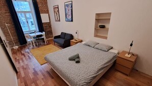 Una camera da letto con un letto, una scrivania, una sedia e un divano.