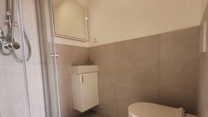 Ein Badezimmer mit Dusche, Toilette und Waschbecken.