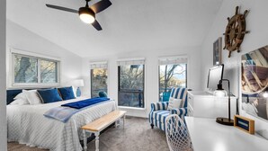 A bedroom with a bed, a desk, a chair, a ceiling fan, and a ship's wheel decoration. - Anchors Away-Private Dock & Slip + Fire Pit + Kayak + Grill (Sunrise Beach)