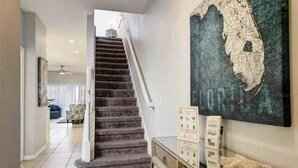 Eine Treppe führt zu einer zweiten Etage, ein großes Kartenkunstwerk ist an der Wand angebracht und ein Schreibtisch mit Informationsbroschüren steht bereit.
