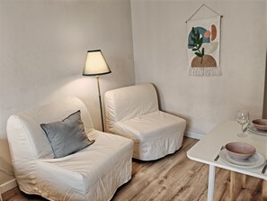 A minimalist room with two white armchairs, a small white table with bowls and a wine glass, and a floor lamp. - Clean apartment easy location (Praha 3)