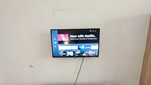 A television mounted on a wall displaying the Netflix interface.