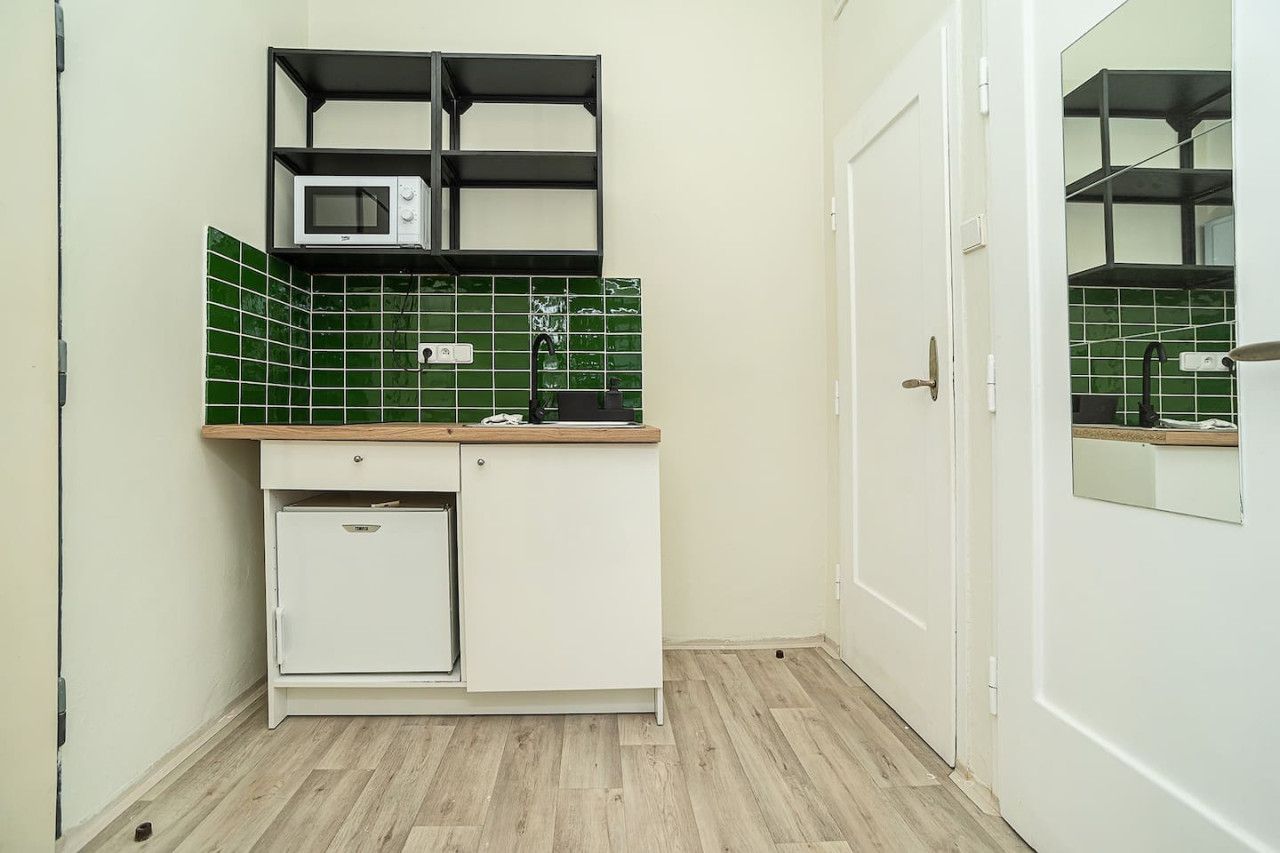A compact kitchen with a microwave, a sink, and a small refrigerator.