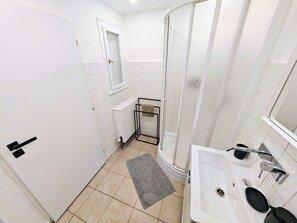 A modern bathroom with a shower, a sink, and a toilet. - Fun bright studio with flat screen TV (Prague)