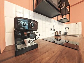 A modern kitchen with a black coffee machine, a kettle, and a sink. - Fun bright studio with flat screen TV (Prague)