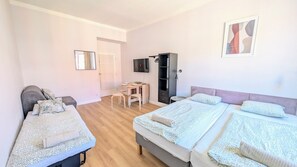 A bedroom with two beds, a desk, and a TV. - 8 bed flat in great location (Praha 3)