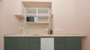 A compact kitchen with a microwave, sink, and dishwasher.