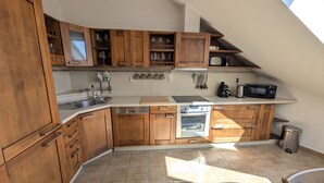 Une cuisine avec des meubles de rangement en bois, un évier, un lave-vaisselle, un four et un four à micro-ondes.