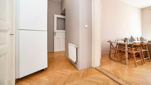 Una cucina moderna con mobili bianchi, forno integrato e zona pranzo con sedie e tavolo di legno.