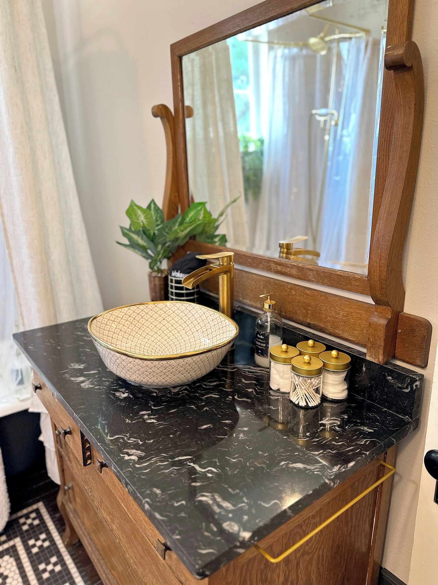 A bathroom vanity with a bowl sink, a mirror, and a marble countertop.