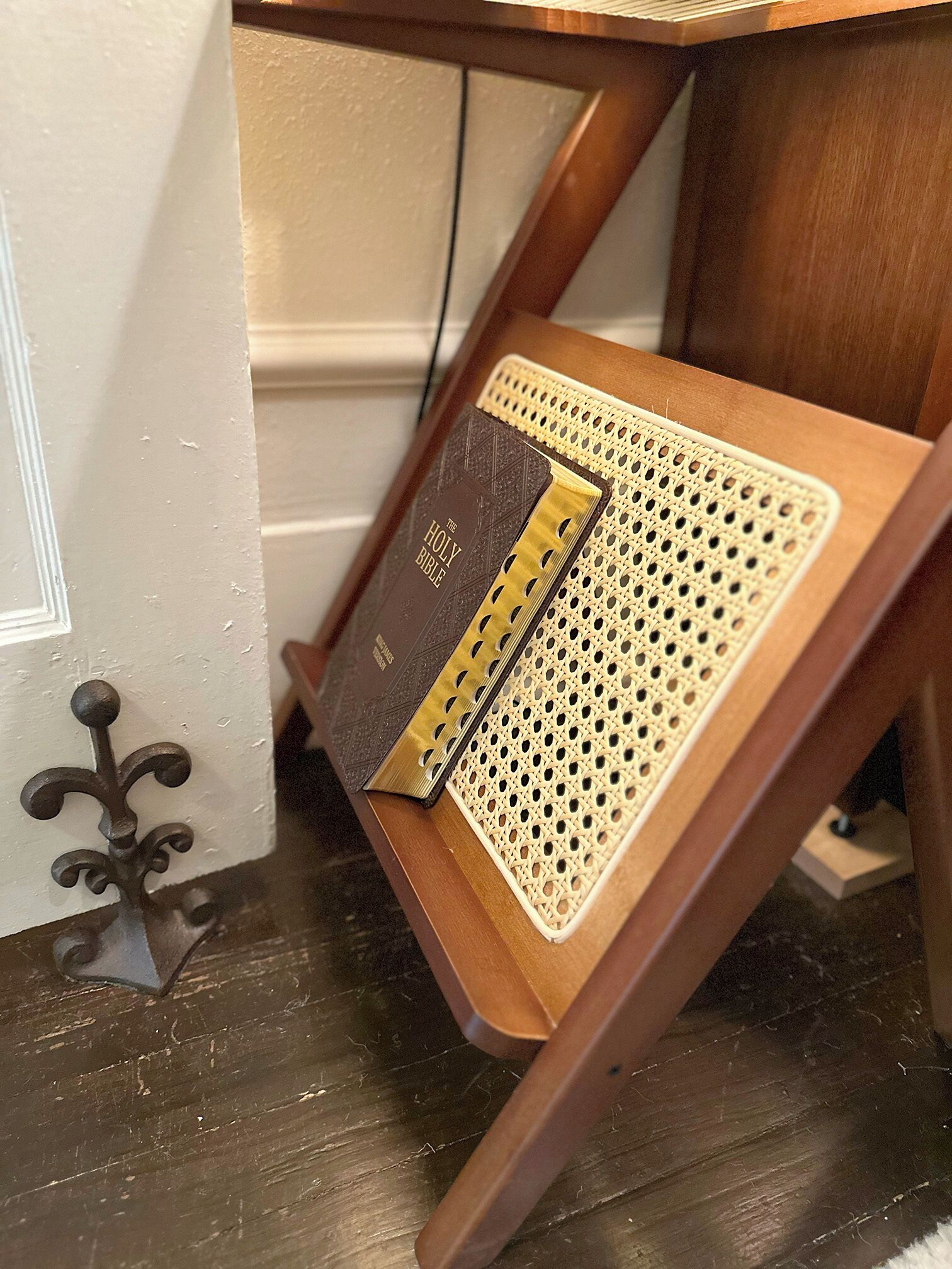 A wooden chair with a woven tray table holding a book and a decorative item.