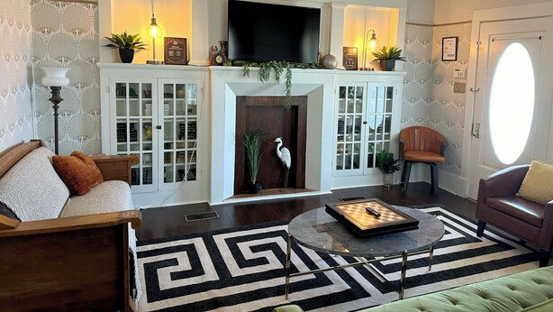 A living room with a fireplace, a television, and a coffee table. - Cane River Living Downtown I Historic District (Natchitoches)