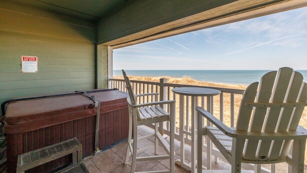 A covered outdoor area with a grill, Adirondack chairs, and a view of the beach. - FFR209 Beach Hideaway by First Flight Rentals (Kill Devil Hills)