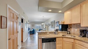 A modern kitchen with granite countertops, stainless steel appliances, and wooden cabinets. - FFR201 My Happy Place by First Flight Rentals (Kill Devil Hills)