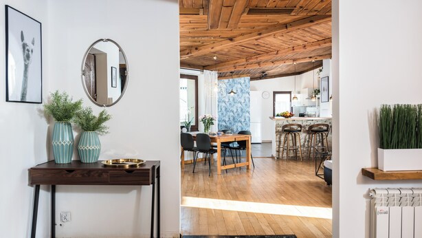 A modern kitchen with wooden flooring, a dining area with a wooden table and chairs, and a kitchen island with bar stools. - ★ The Charm of the Center: Double Beauty ★ (Kraków)