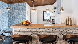 A kitchen with a wooden countertop, stone backsplash, and three bar stools. - ★ The Charm of the Center: Double Beauty ★ (Kraków)