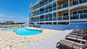 A multi-level hotel with a swimming pool and lounge chairs. - WV25 Surf Shack by First Flight Rentals (Rodanthe)