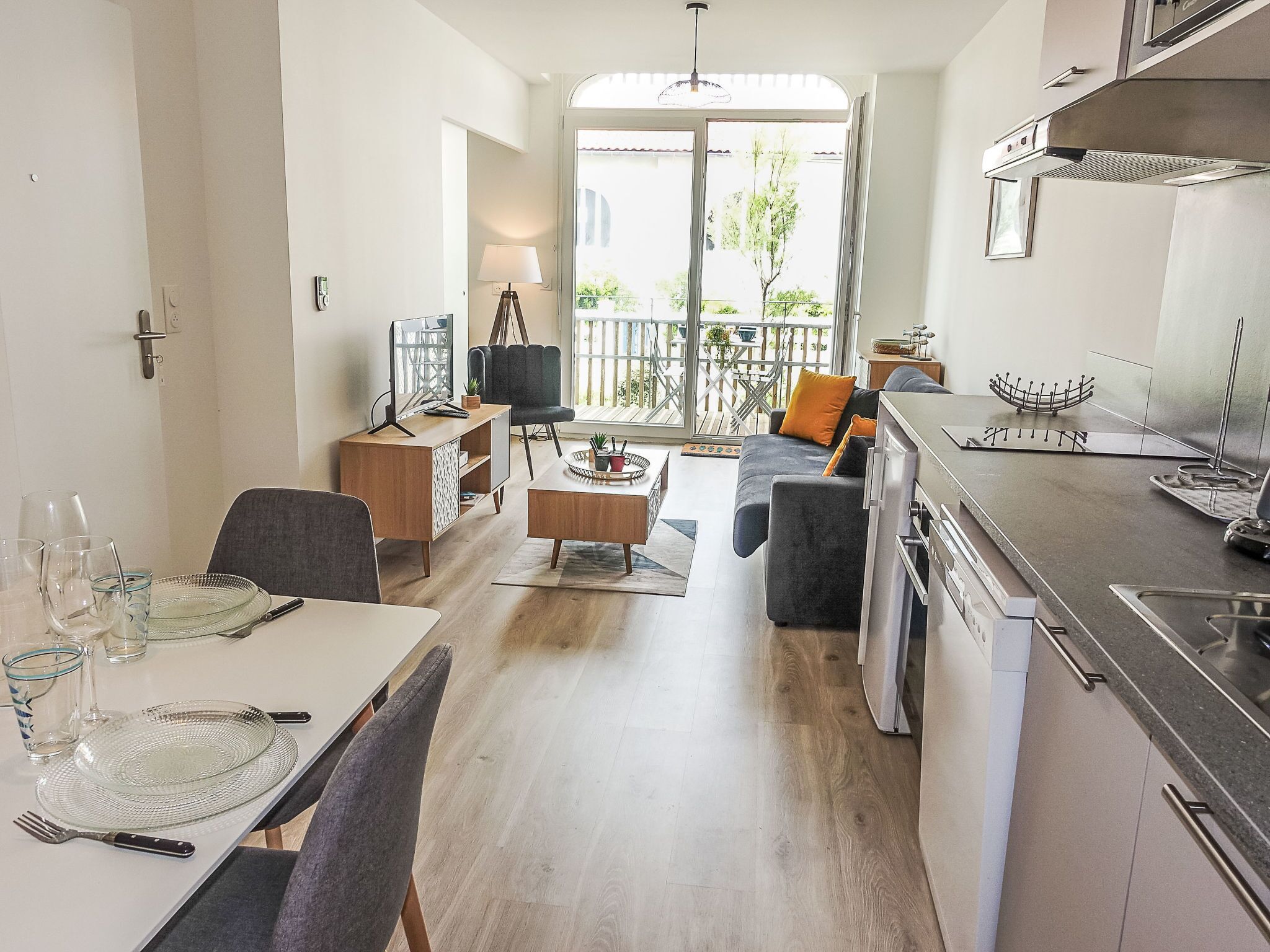 A modern apartment with a dining area, living room, and kitchen.
