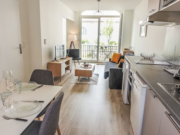 A modern apartment with a dining area, living room, and kitchen.