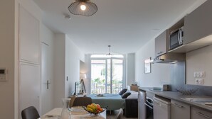A modern kitchen with a dining area, a large window, and a view of the outdoors. - Cap Océan by Interhome (Capbreton)