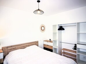 Restful retreat with a large bed, wardrobe, and bedside table.