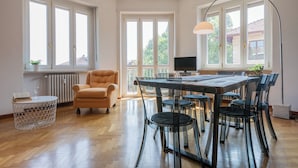 A spacious room with a large dining table, multiple chairs, a sofa, and a TV. - Mole View by Wonderful Italy (Turin)