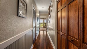 A hallway with wooden doors, a radiator, and a framed picture on the wall. - CSC3M Dawn Patrol by First Flight Rentals (Kill Devil Hills)