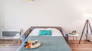 A modern bedroom with a bed, bedside table, lamp, and a tray with breakfast items. - Cap Océan by Interhome (Capbreton)