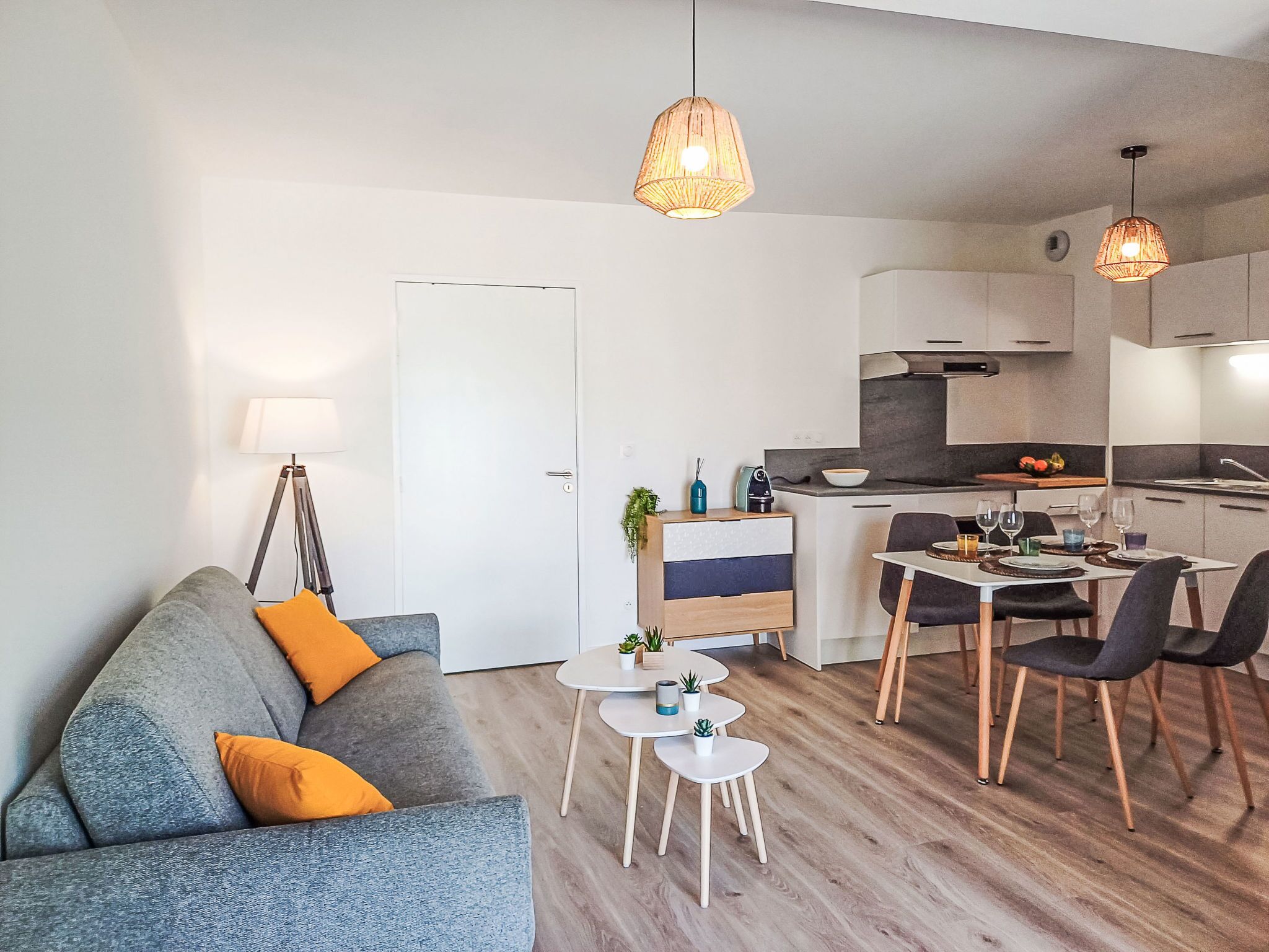 A modern apartment with a living room, dining area, and kitchen.