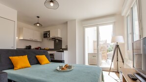 A compact room with a bed, a sofa, a dining table, and a kitchenette. - Cap Océan by Interhome (Capbreton)