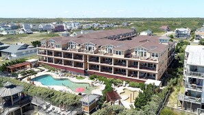 Um hotel com vários andares, área de piscina, espaço para sentar ao ar livre e vista do bairro circundante.