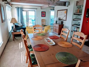 A dining area with a wooden table, chairs, and a view of the outdoors.