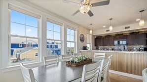 Cozinha moderna com armários escuros, painel de backsplash em padrão herringbone e uma ilha central.