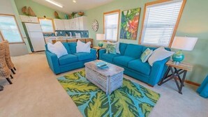 A living room with two blue sofas, a coffee table, and a patterned rug.