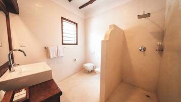 A bathroom with a sink, toilet, and shower.