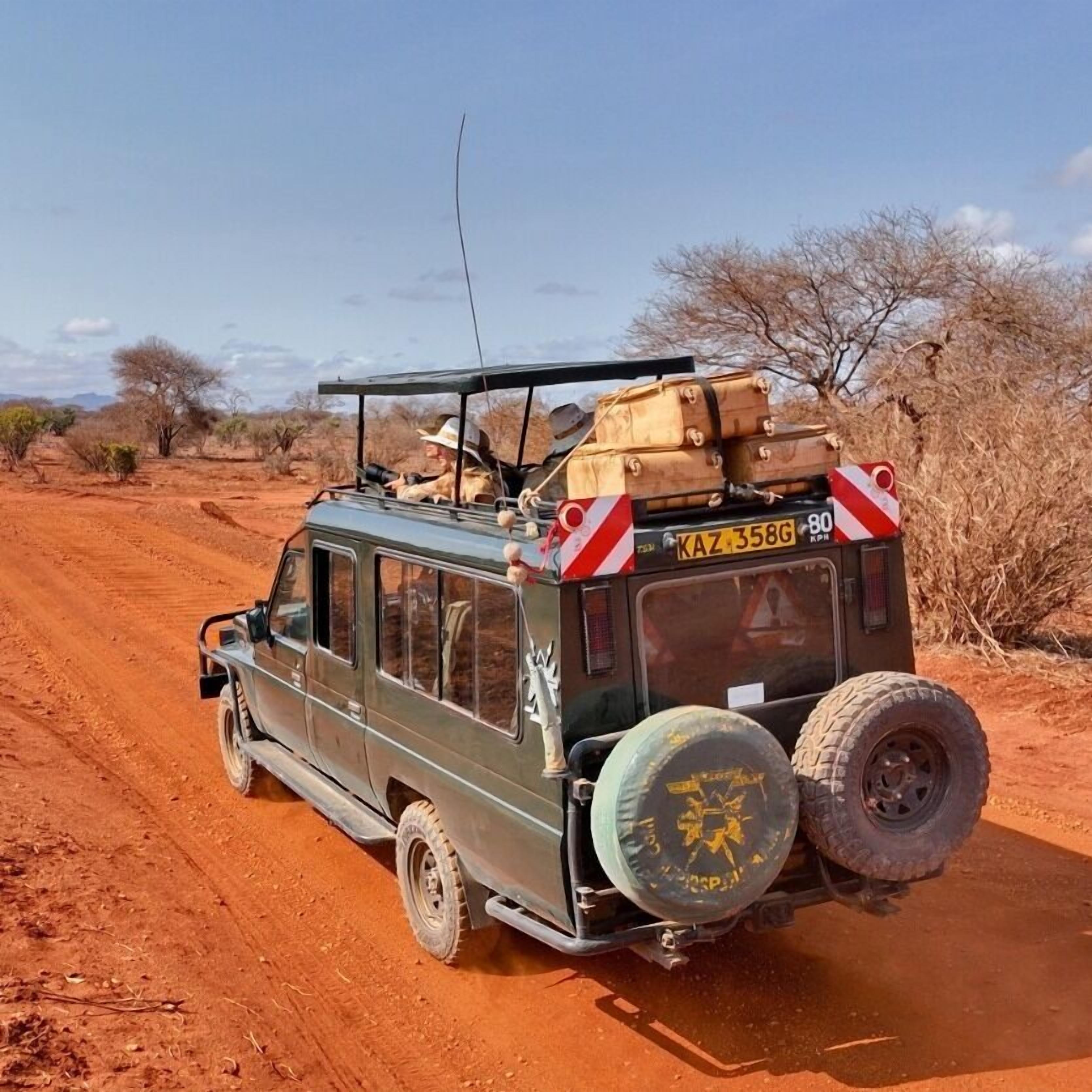 A vehicle with luggage on a dirt road.