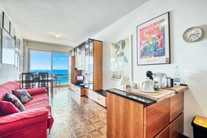 Uma cozinha moderna com armários de madeira, um sofá vermelho e obras de arte nas paredes.