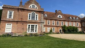A large brick building with multiple windows and a central entrance. - Modern 2BR in Surrey | Pet-Friendly, WiFi, Parking (Surrey)