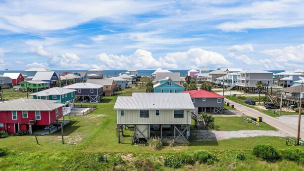 A coastal residential area with houses on stilts, some with attached decks, and a clear view of the ocean. - Awesome & Affordable 3 Bdrm, 2 Ba with easy beach access, and Gulf & Bay Views.  (Gulf Shores)